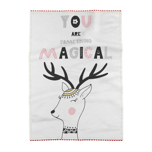 Tea towel printed on a pale grey ground, reading You are something magical, above a reindeer in a small gold cap, with black antlers and a happy closed eye