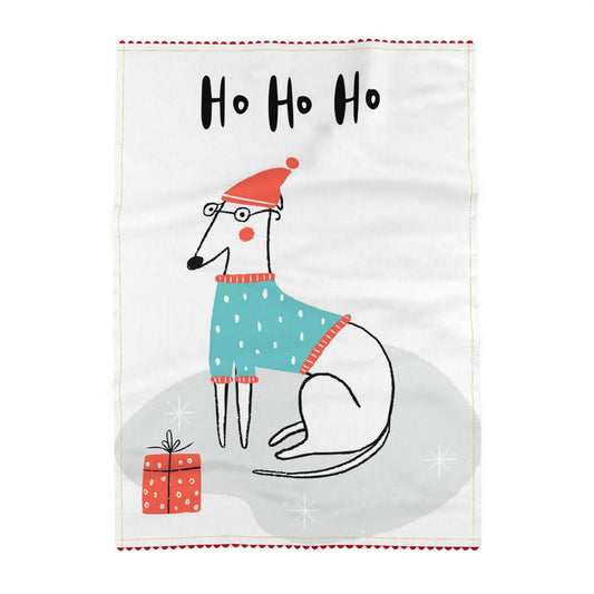 Ho Ho Ho: Tea towel reading Ho ho ho, above a white dog in a red hat, a round black glasses and teal polka dots jumper, lying on a grey rug beside a red present