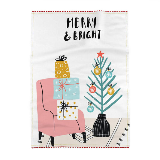 Tea towel reading Merry and bright, above a pink armchair stacked with presents, beside a small Christmas tree with colourful baubles and a big orange star on top, in a black and white pot. Off-white ground