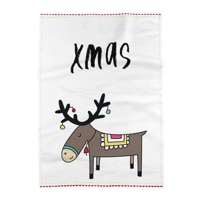 Tea towel reading xmas, above a reindeer in profile with baubles hanging from its antlers and a patterned blanket on its back. Off-white ground