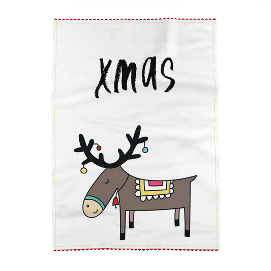 Tea towel reading xmas, above a reindeer in profile with baubles hanging from its antlers and a patterned blanket on its back. Off-white ground