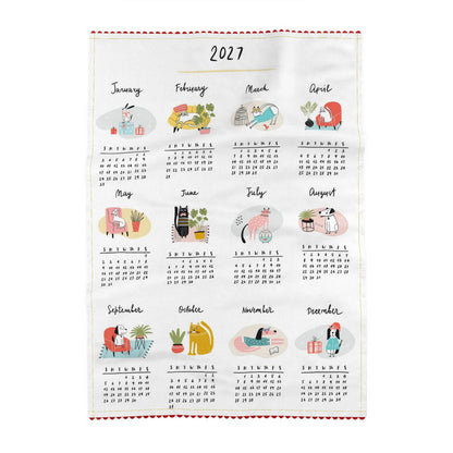 Tea towel printed with a 2027 calendar, twelve months in rows of four, each with a small illustration of a cat or a dog